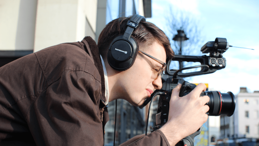 man wearing headphones using video camera 