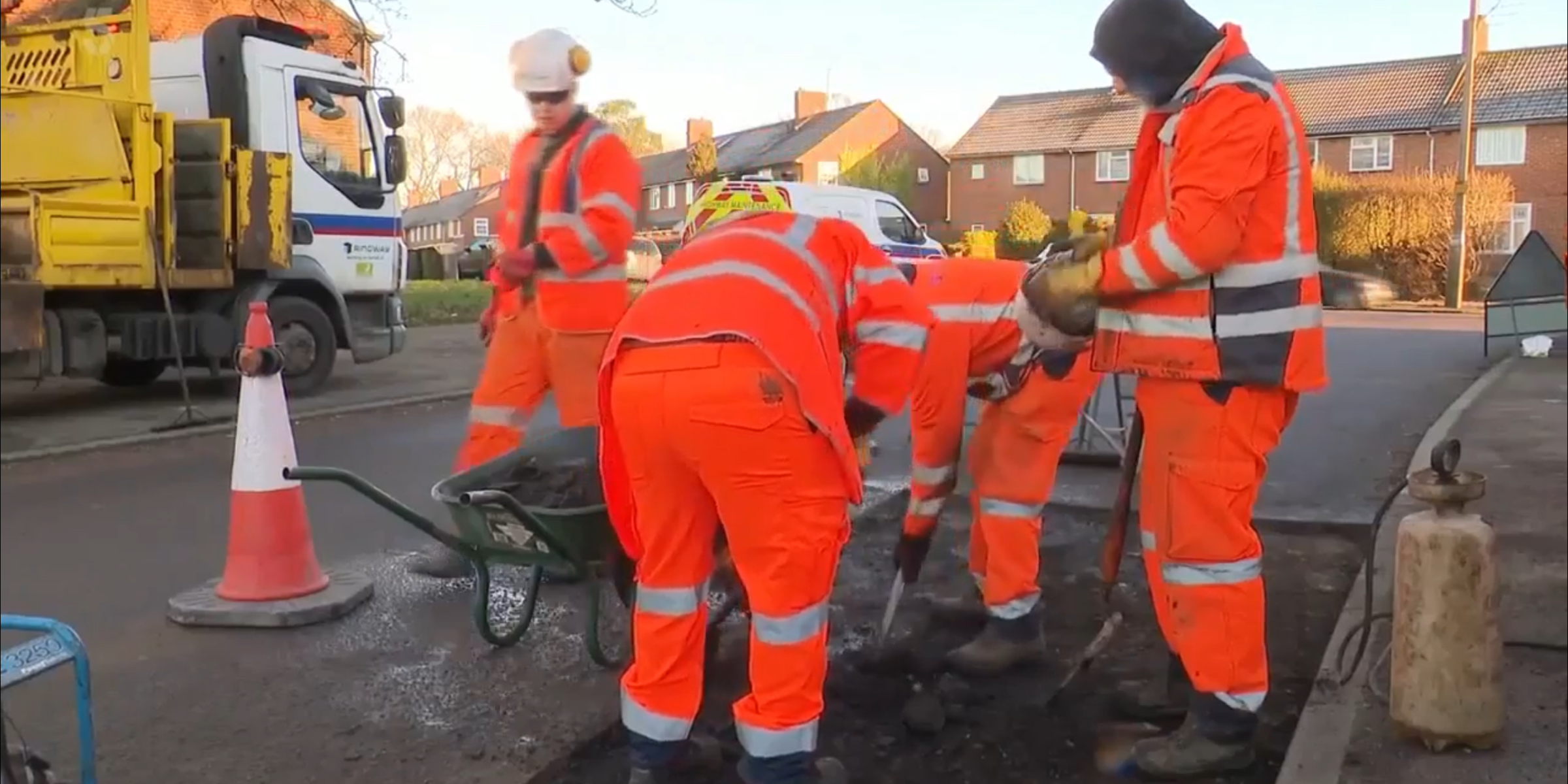 men mending pot hole