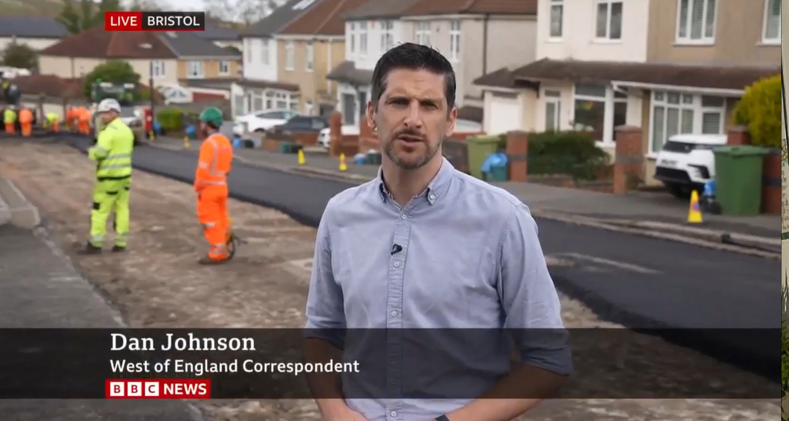 BBC reporter standing on a road that is being repaired